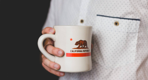 Person holding a California Republic mug wearing a white button-up shirt