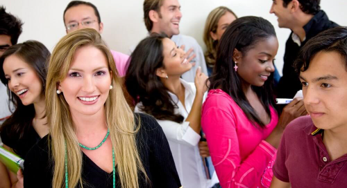 Group of diverse young adults socializing and smiling at an event.