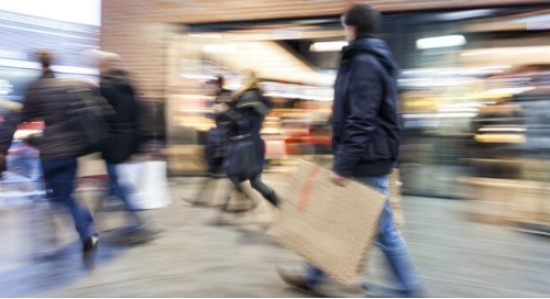 People shopping in a busy mall with motion blur effect.