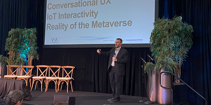 Man speaking at a tech conference on Conversational UX, IoT Interactivity, and the Metaverse.
