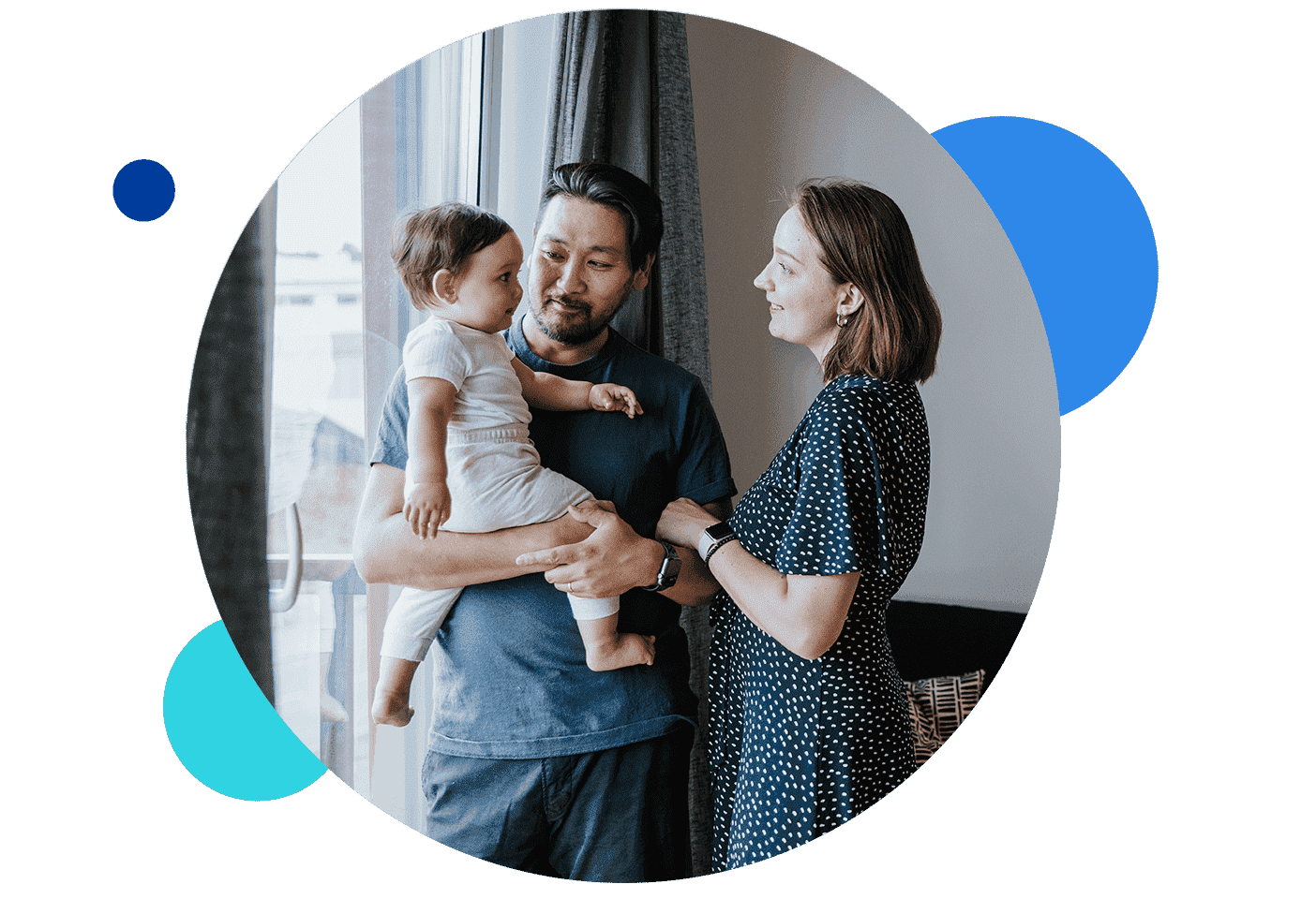 Family standing together with baby in a living room.