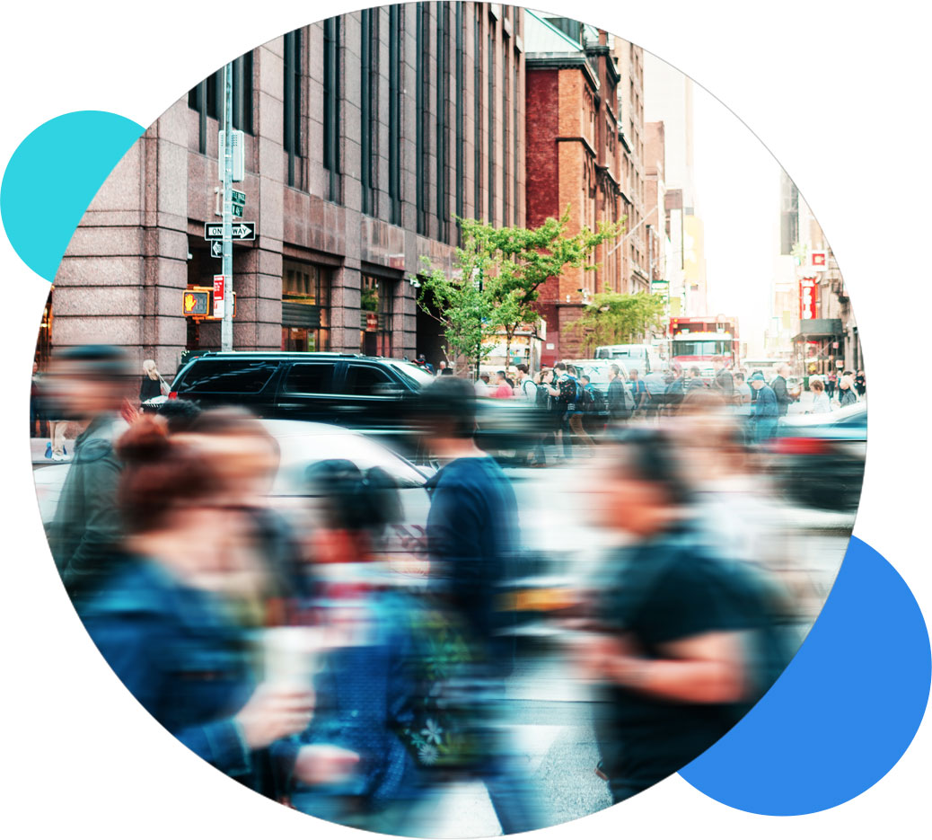 Busy urban street with blurred pedestrians and traffic in a cityscape scene.