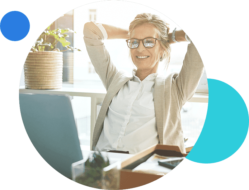 Smiling professional woman relaxing at her desk in a bright office.