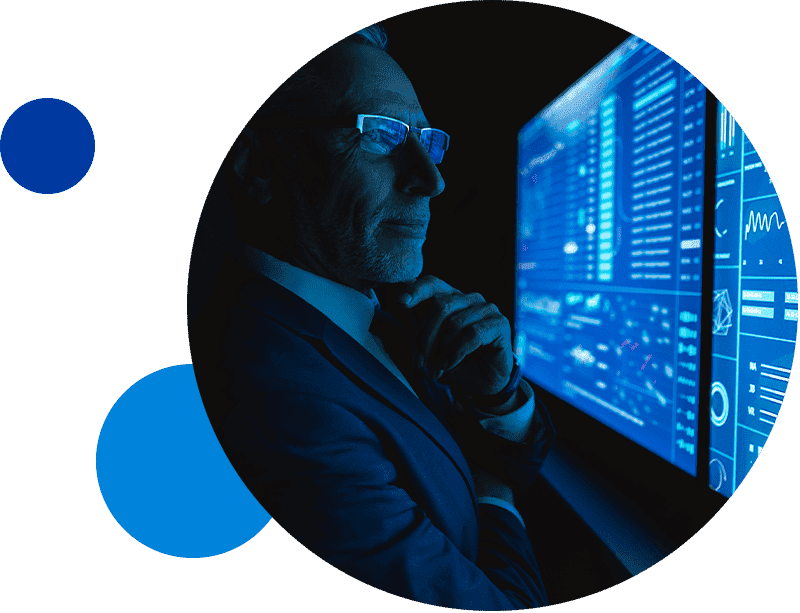 Man analyzing data on a digital screen in low-light setting.