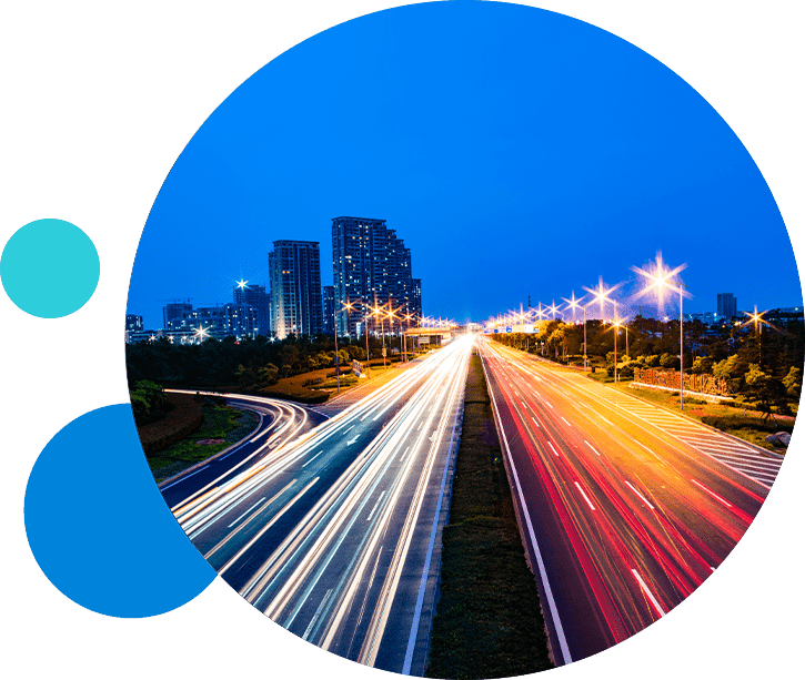 ConsumerFinance_RetainCustomers City highway at night with streaking car lights against a backdrop of illuminated skyscrapers.