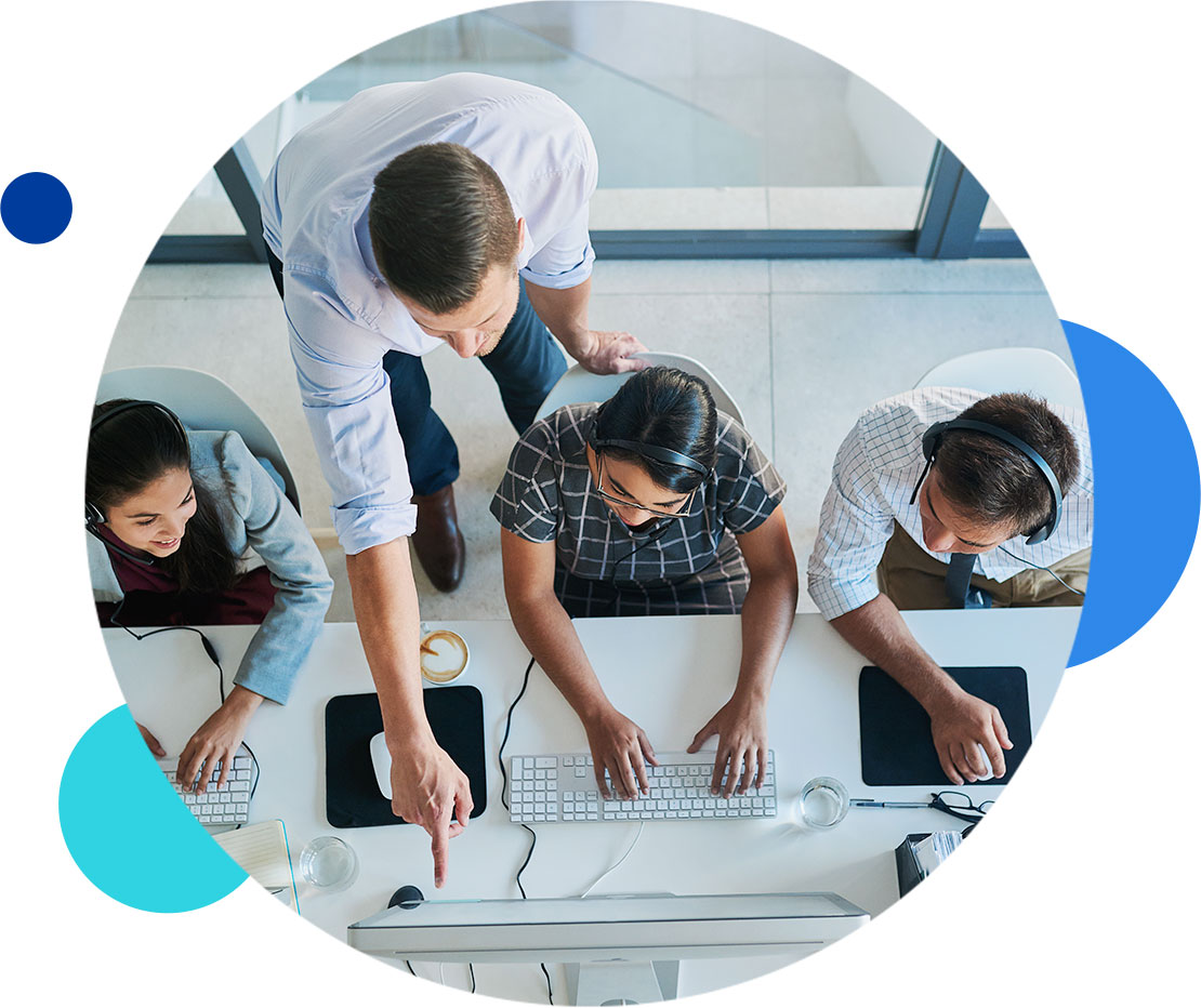 Team collaborating on computers in a modern office environment.