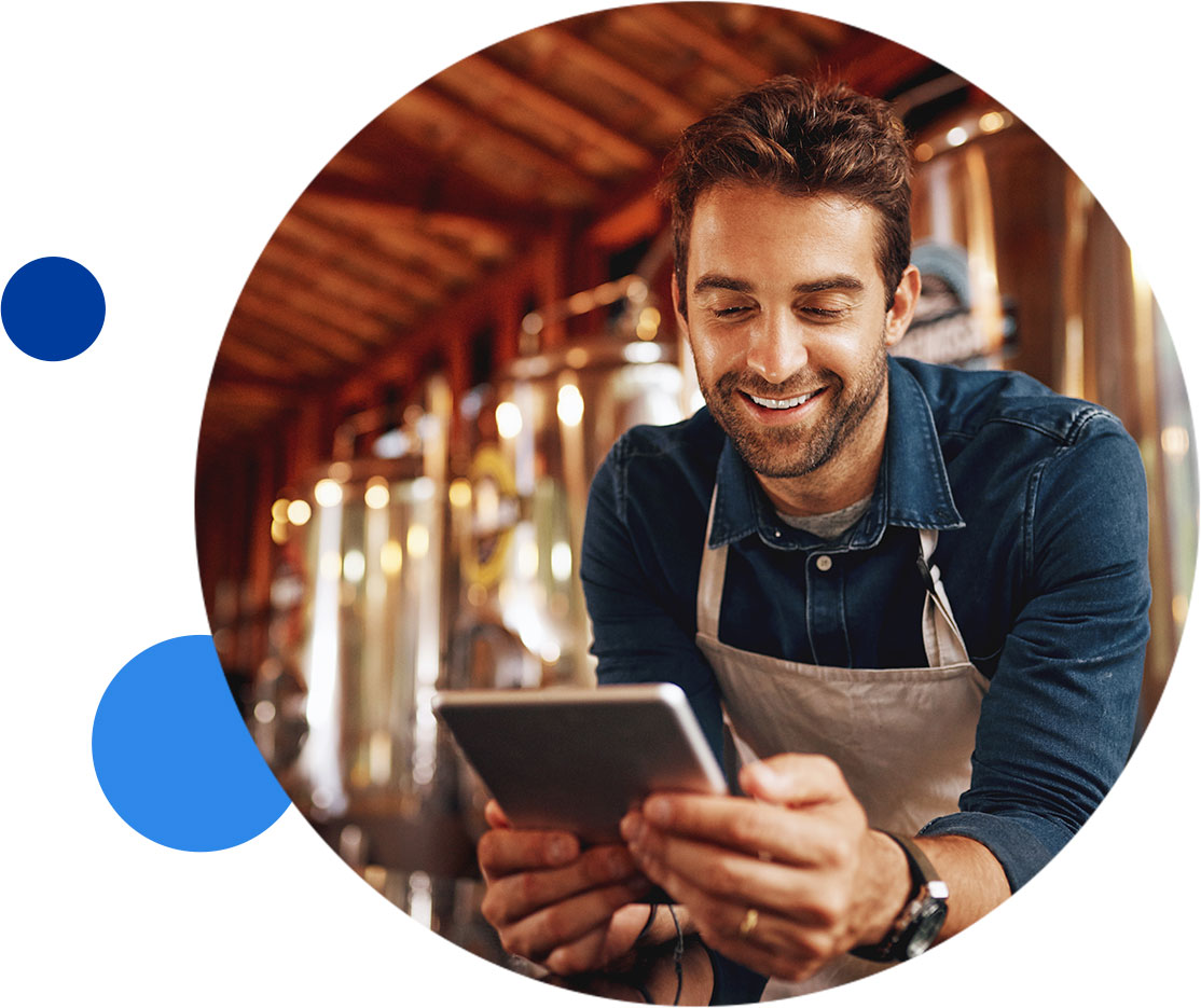 Man smiling while using a tablet in a brewery
