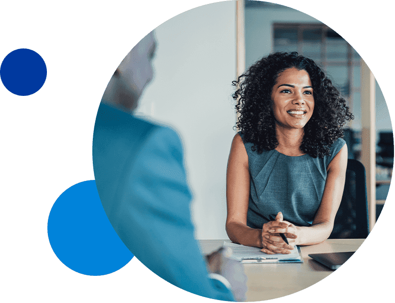 Businesswoman smiling during a meeting in an office setting.