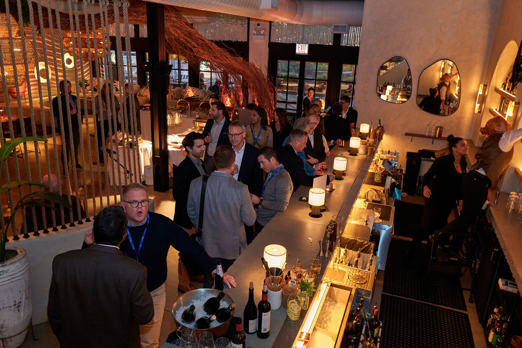 L1090019 Bar gathering with people networking and socializing in a dimly lit, stylish venue.