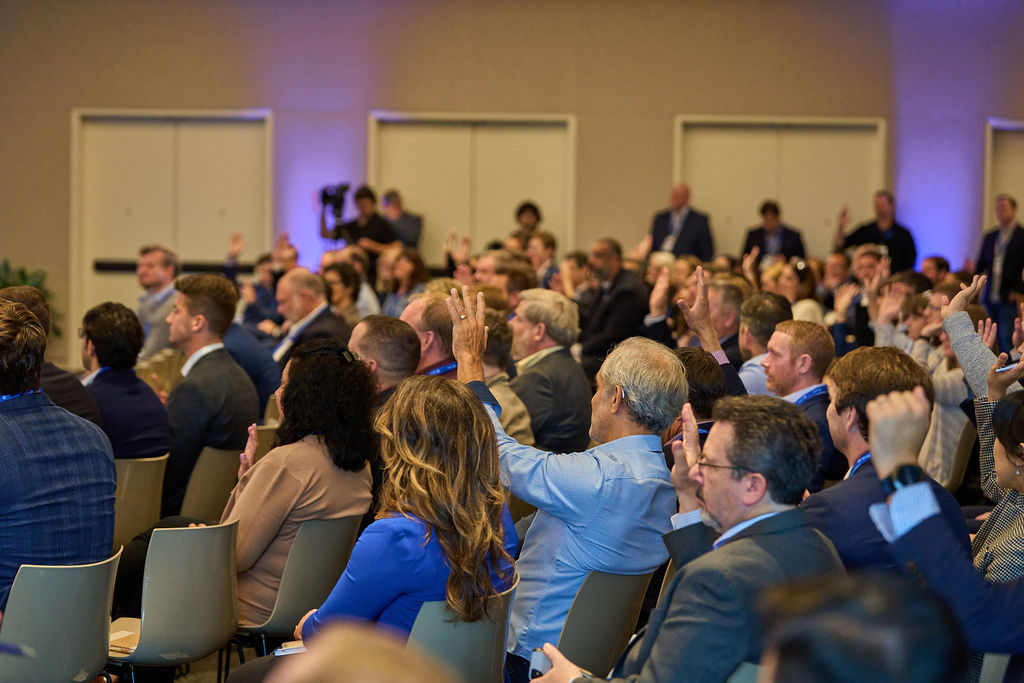 _P1_3421 Audience members raising hands during a conference session.