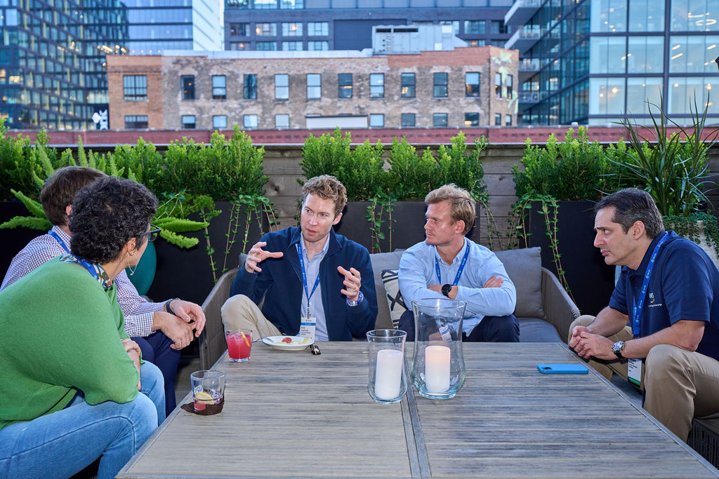 _P2_7612 Group of people having a discussion on a rooftop patio.