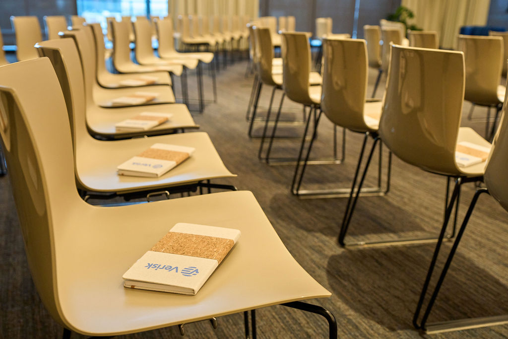 _P2_7888 Empty conference room with chairs and notepads set up for an event.