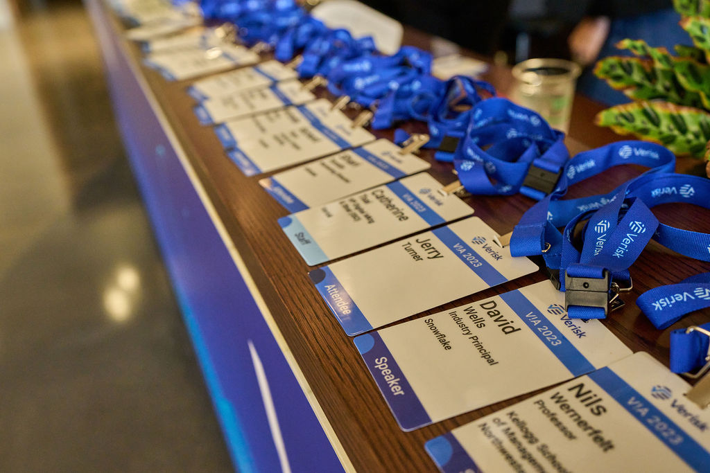 _P2_7927 Conference name badges and blue lanyards on a registration table.