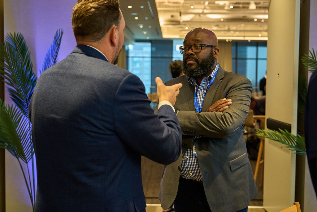 _P2_8219 Two professionals engage in a serious discussion at a business conference.