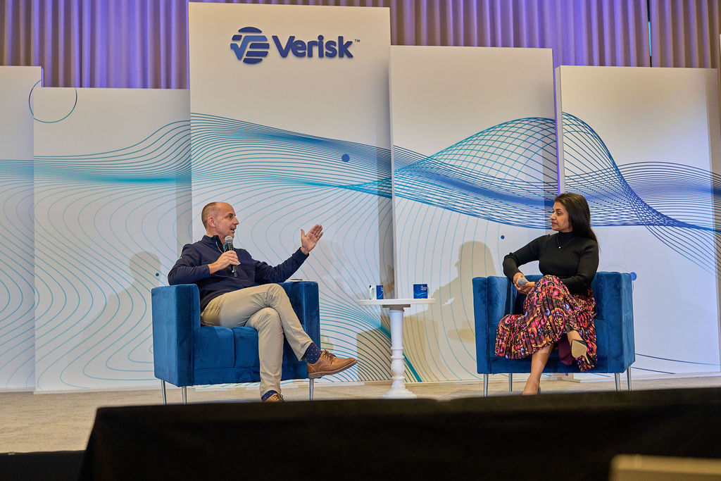 _P2_8418 Speakers on stage at a Verisk event engaging in a discussion.