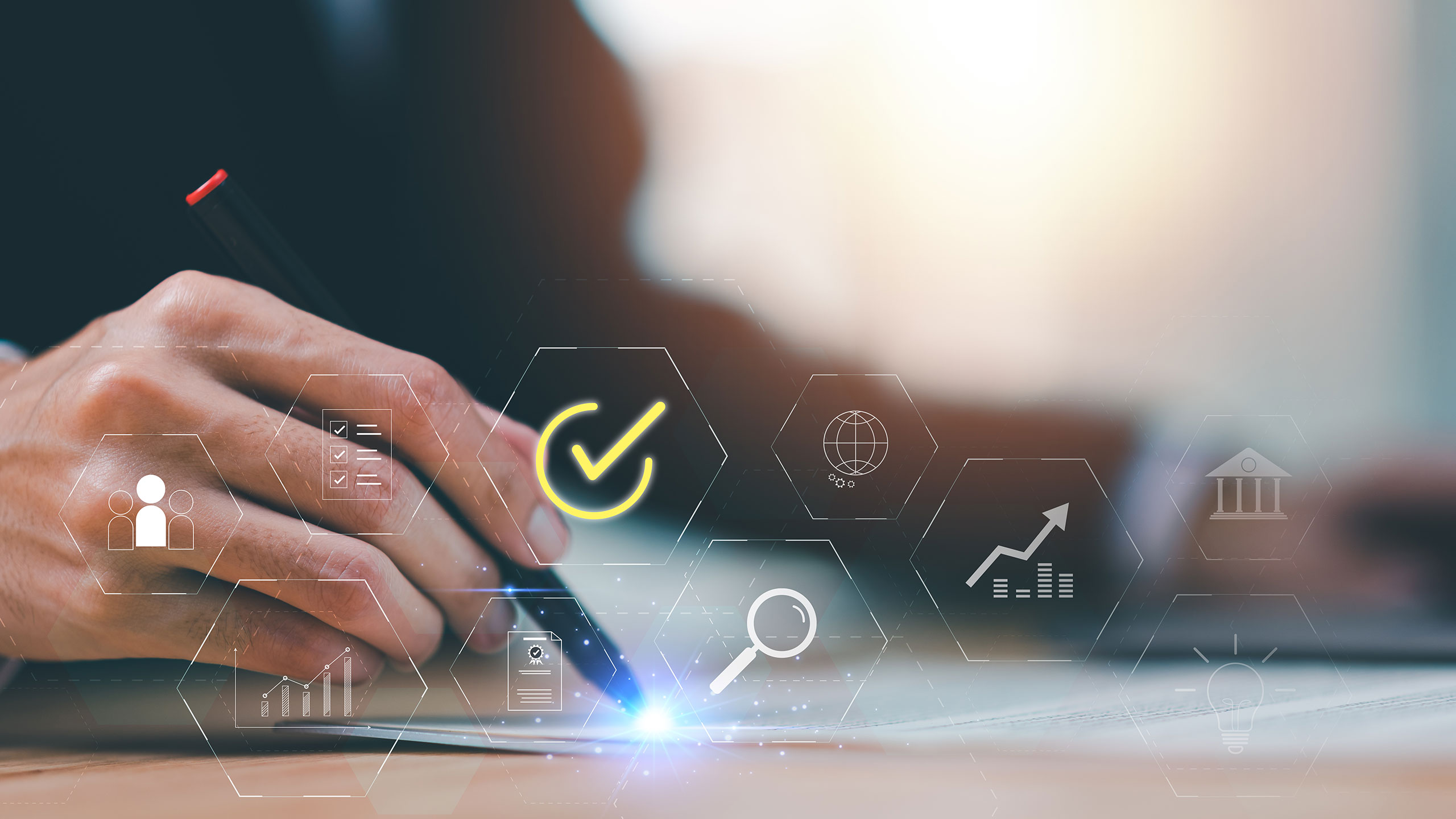 Businessman's hand writing on a document with digital icons overlaying.