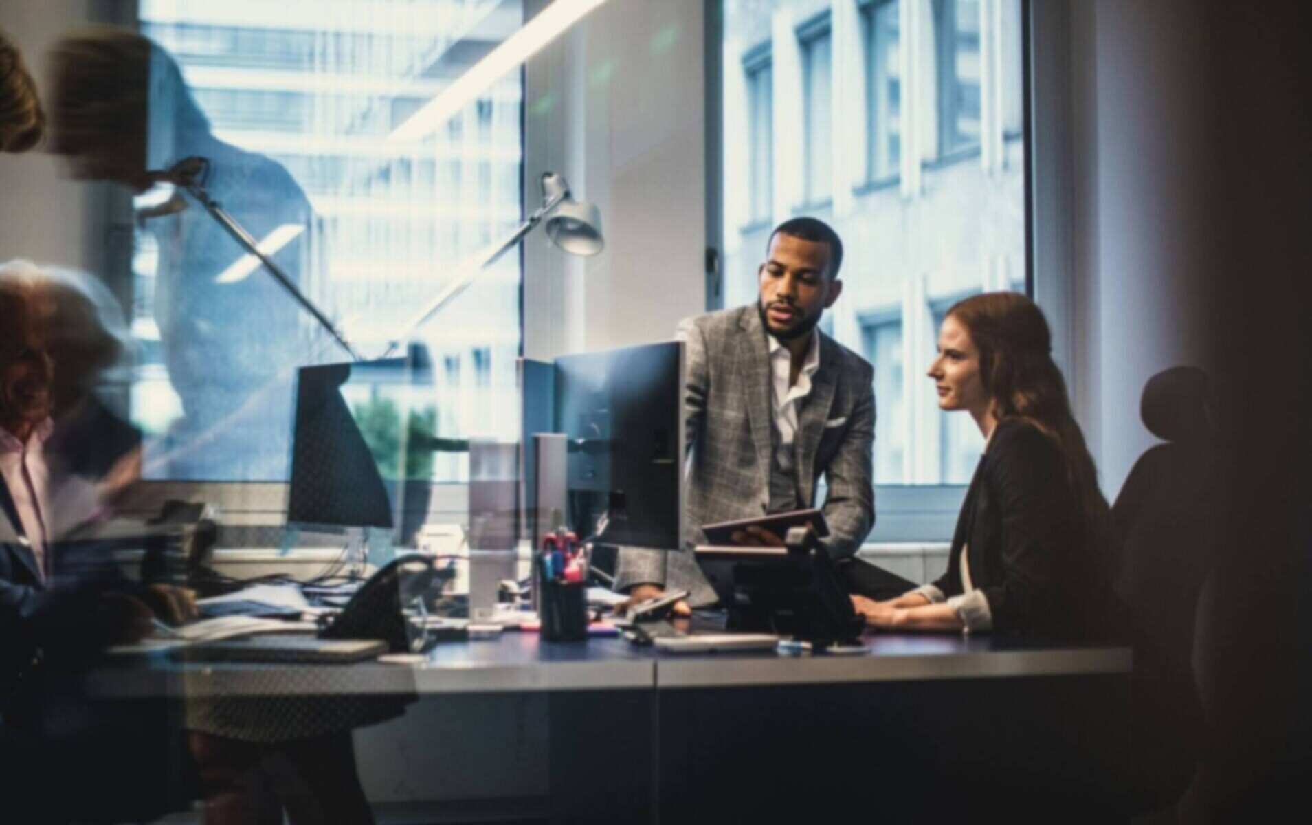 Business professionals collaborating at a modern office desk.
