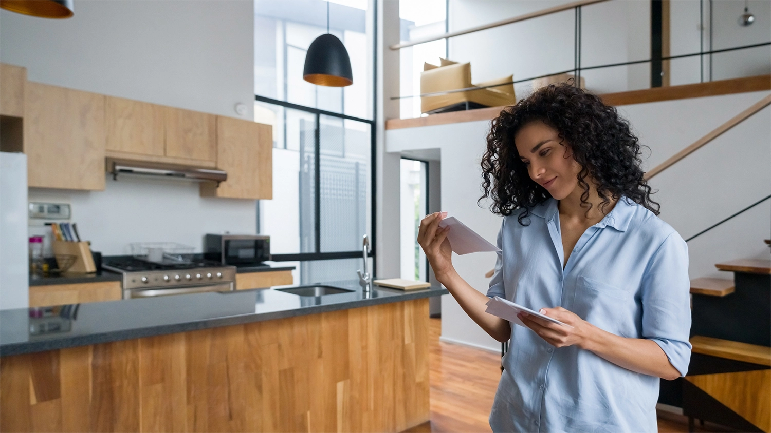 woman in kitchen opening an invitation to apply direct mail offer