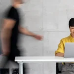 Busy Office Featuring a Focused Professional smiling on a laptop at her desk